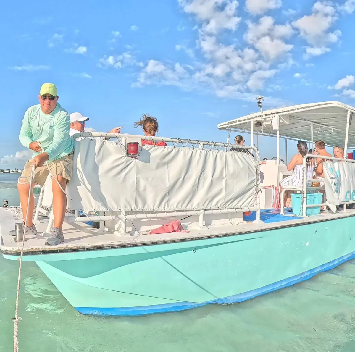 A happy guest in a sun hat enjoying a drink while relaxing in the clear waters of Islamorada.