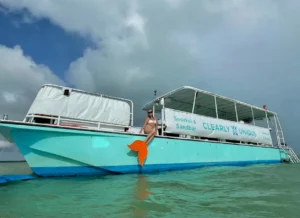 Mermaid sitting on charter boat smiling