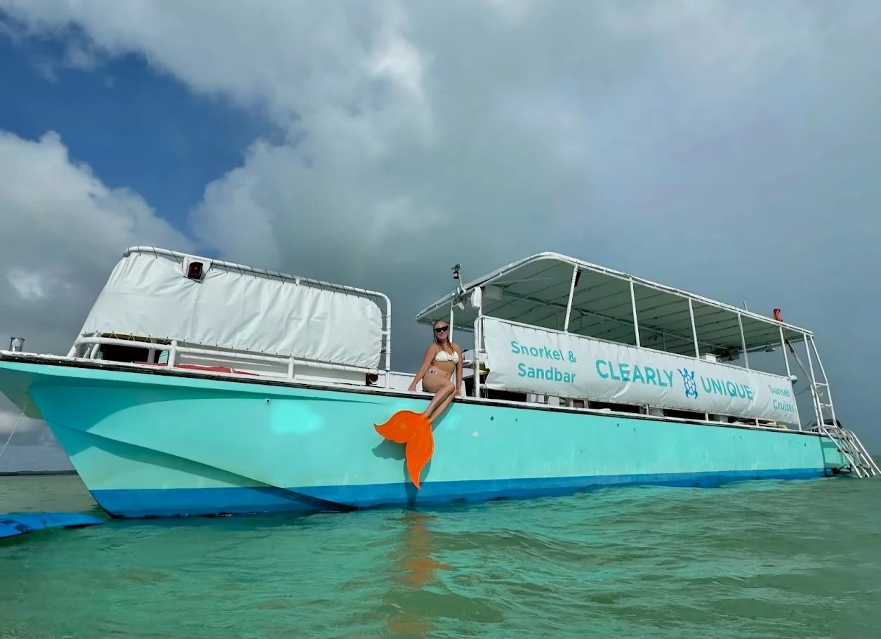 Mermaid sitting on charter boat smiling