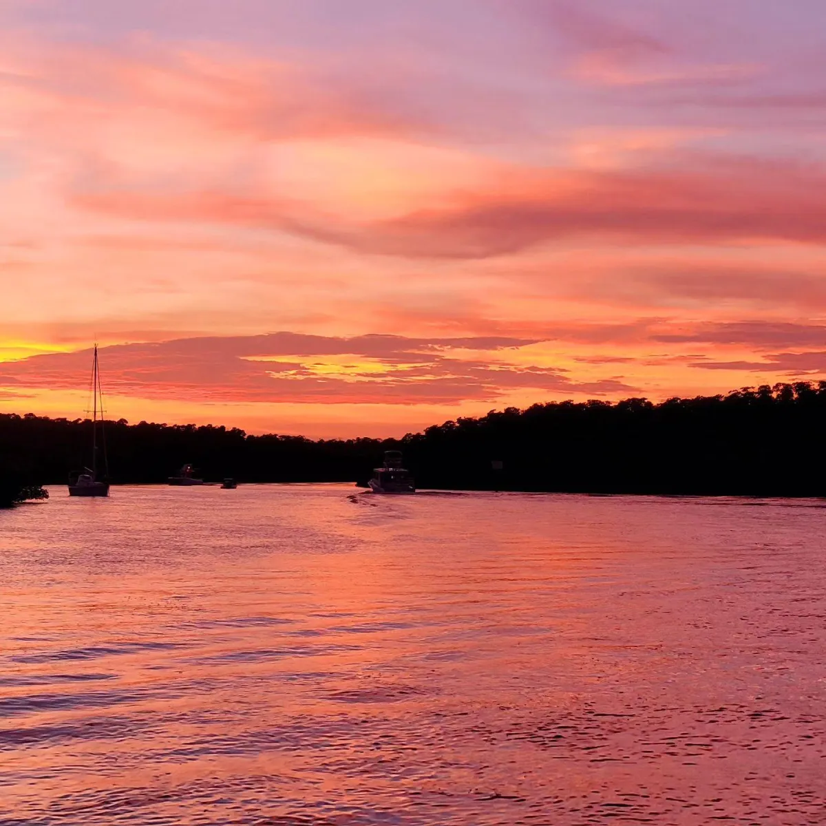 Sunset over calm waters with boats during a charter in Islamorada.