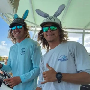 Guest smiling with boat captain and giving thumbs up on a charter