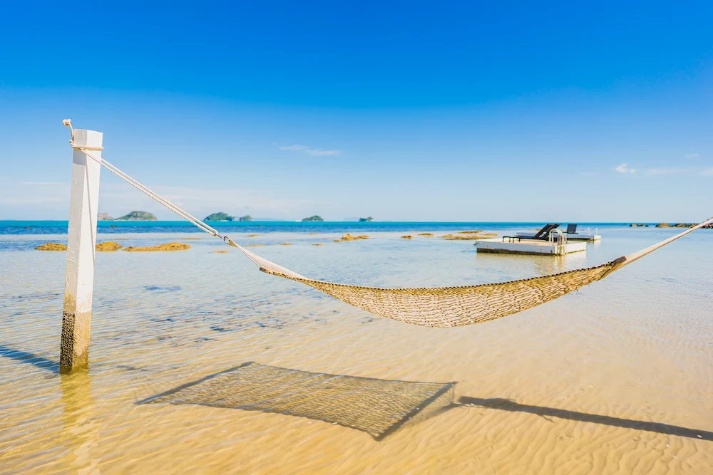 Hammock on tropical beach near ocean perfect for relaxing dining experience