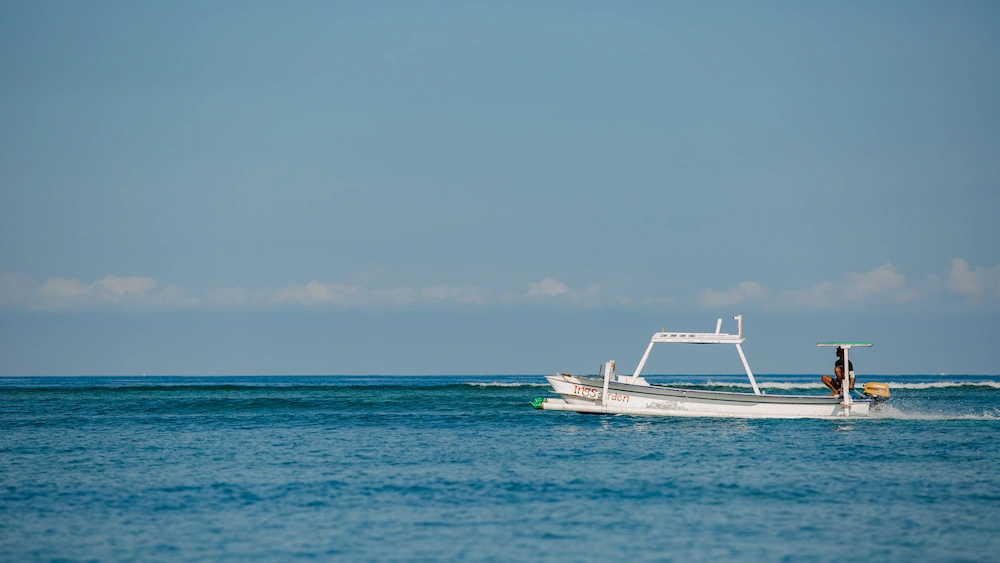 Boat cruising across clear ocean water during scenic island tour