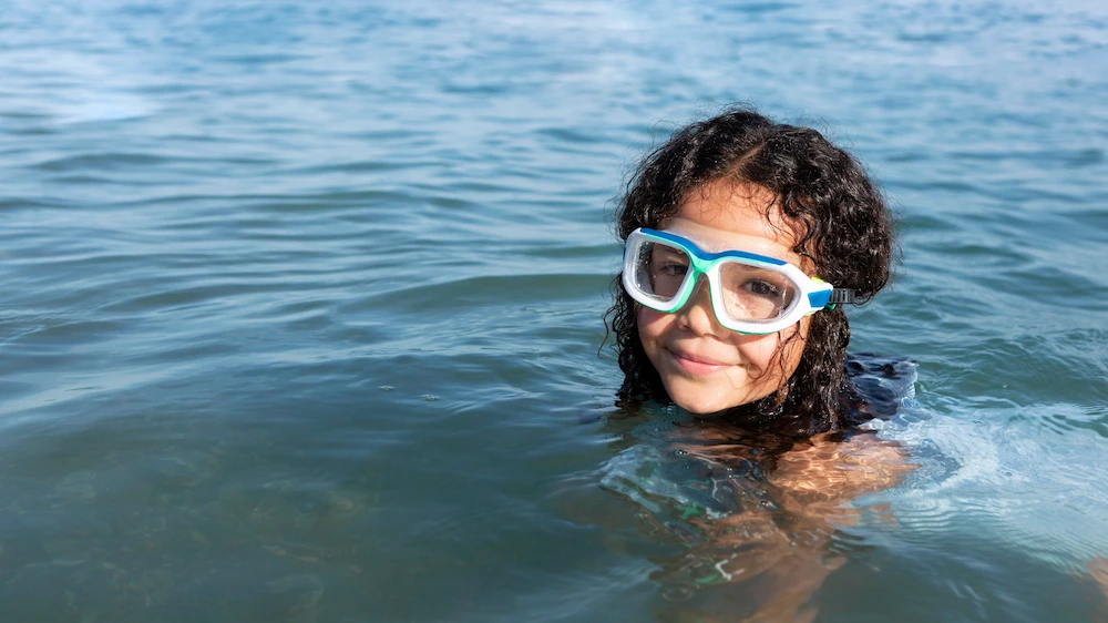 Person enjoying a snorkeling experience in clear ocean water