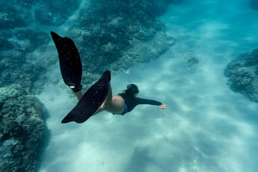 Woman snorkeling with flippers while exploring the clear ocean waters in the Florida Keys.